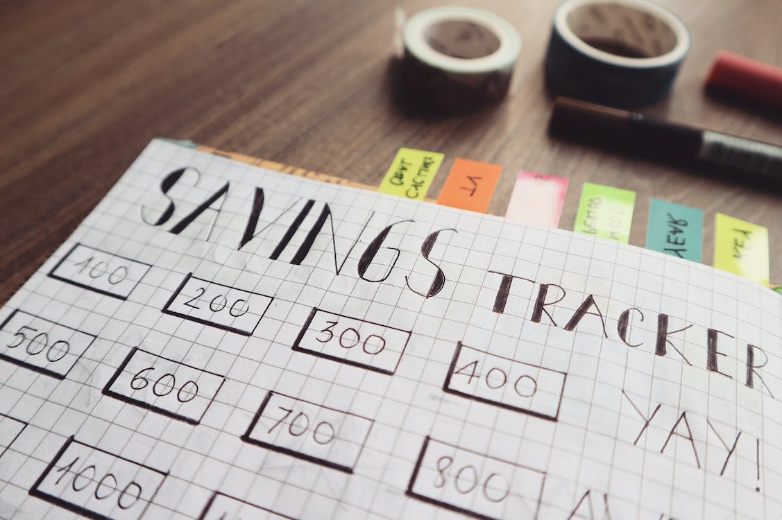 Free Savings Tracker on Brown Wooden Surface Stock Photo